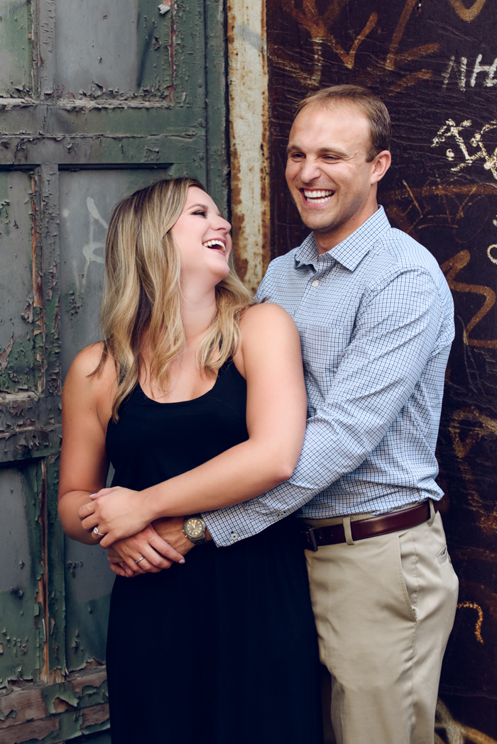 engaged couple laughing together in the Strip District of Pittsburgh, Pennsylvania