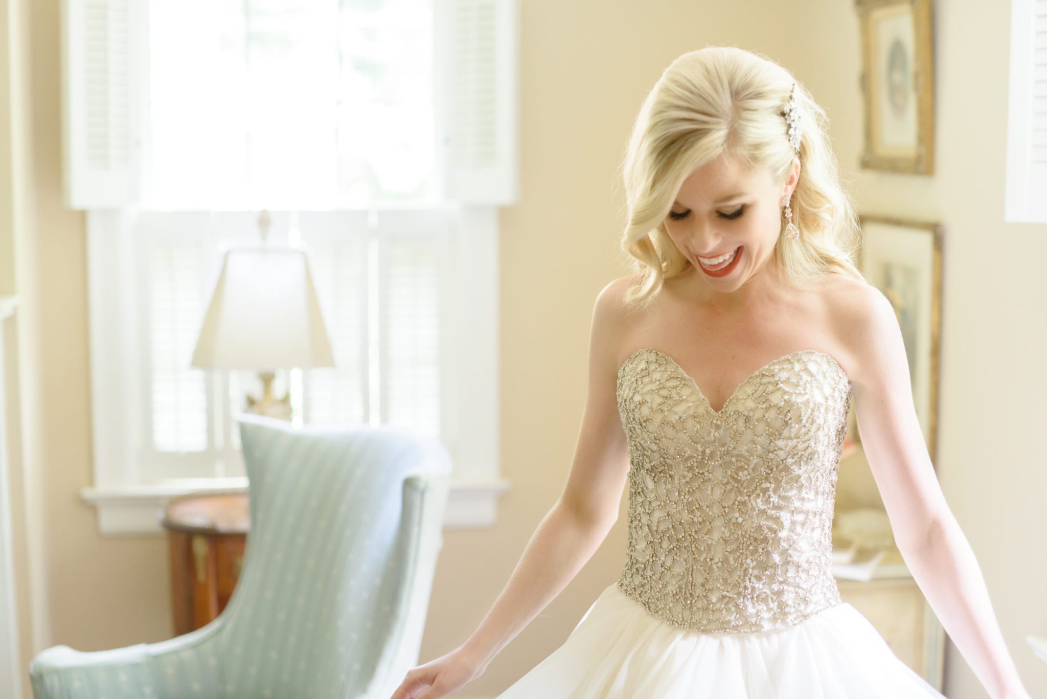 a bride looking at her wedding dress right after she puts it on