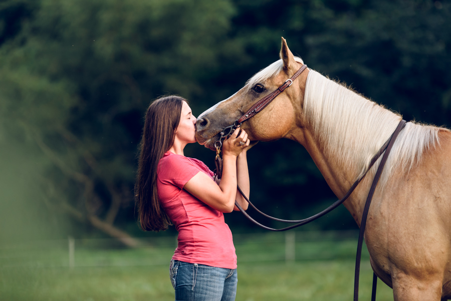 a high school senior kissing her palomino horse at a barn in Irwin, Pennsylvania