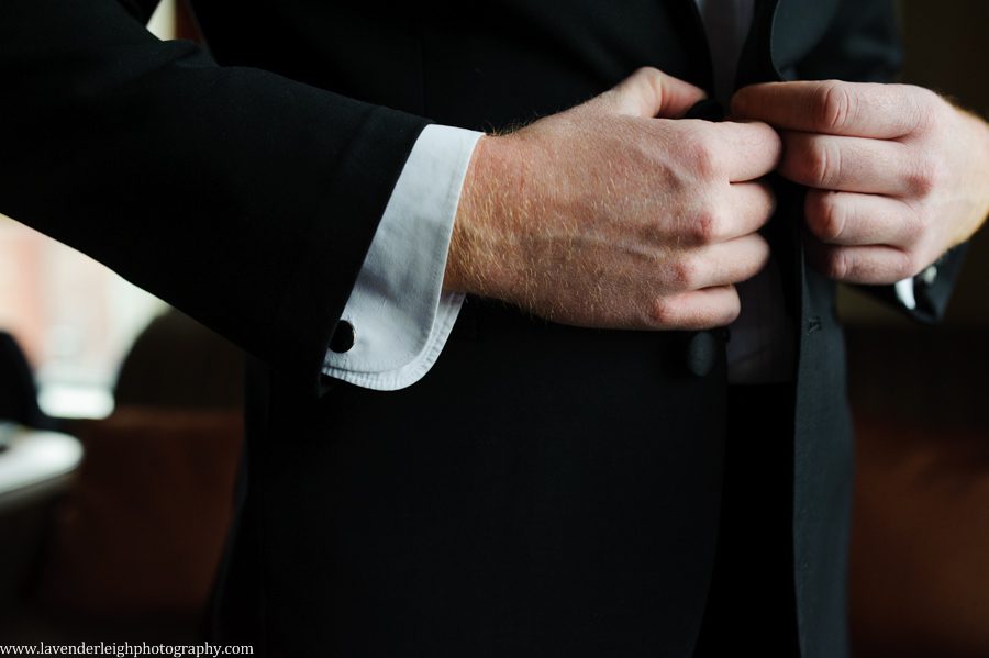 A groom putting on his jacket on his wedding day