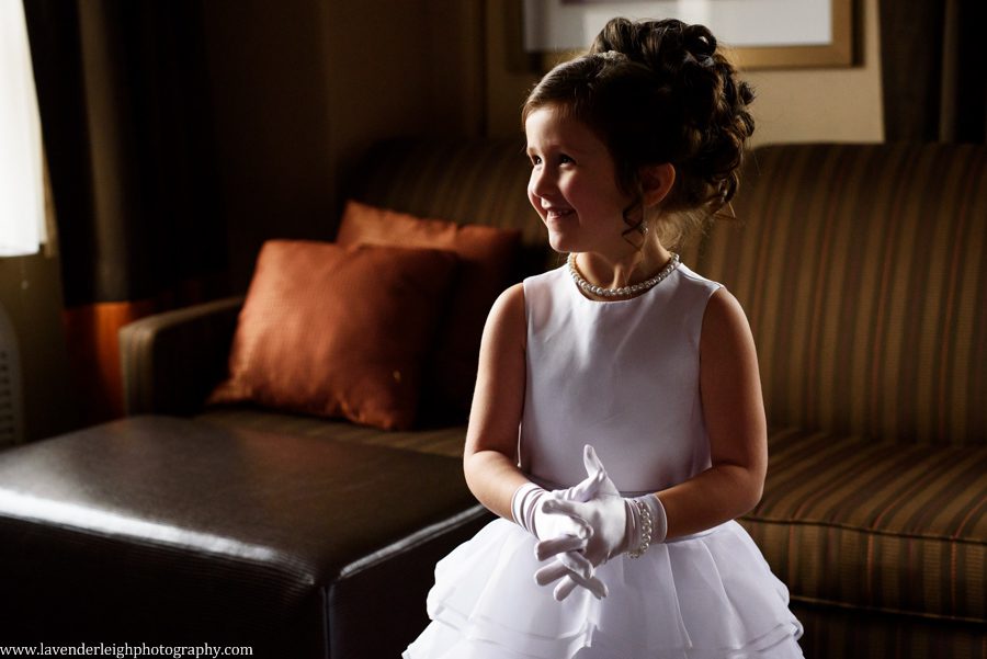 A flower girls looks at the bride with excitment