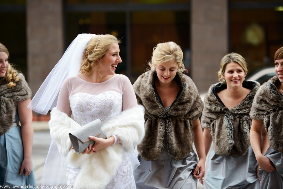 A bride enjoying time with her bridesmaids before her winter wedding ceremony