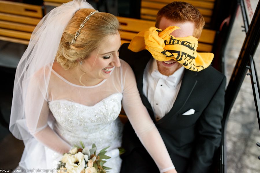 A bride and groom on the trolley, groom is wearing a terrible towel as a blindfold