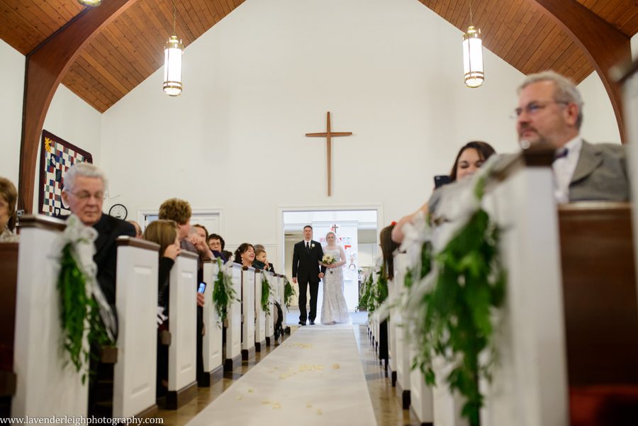 A father walking his daughter down the aisle during her wedding ceremony