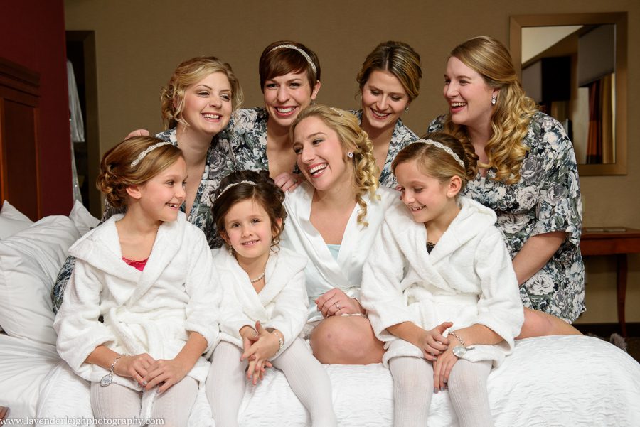 A bride having a moment with her bridesmaids and flower girls before putting on her white winter wedding dress.
