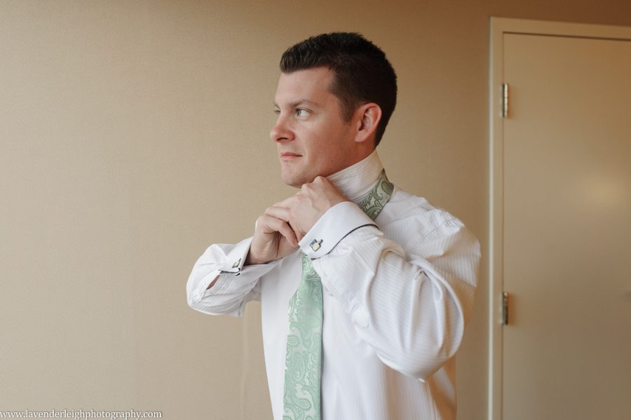 Groom putting on tie, getting ready, wedding day, sage green tie, Sheraton Station Square