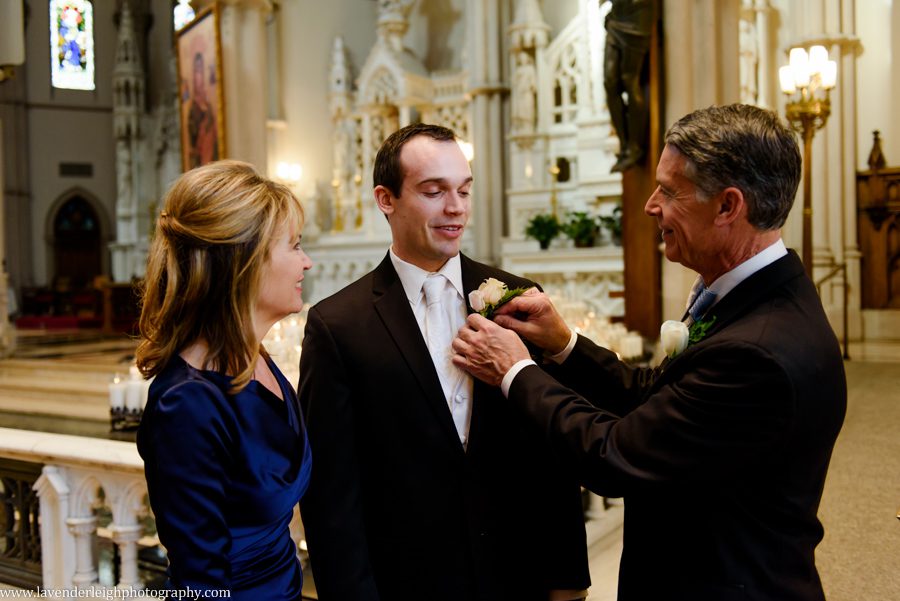 The groom's father pins the boutonniere on him at St. Paul Cathedral