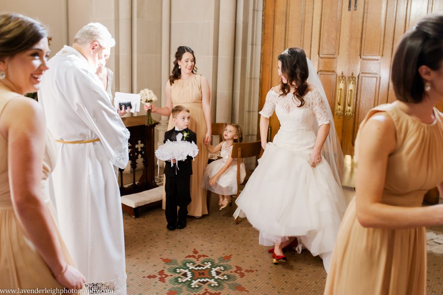 The bride shoes off her red Stuart Weitzman shoes to the Arch Bishop at St. Paul Cathedral in Pittsburgh, Pennsylania