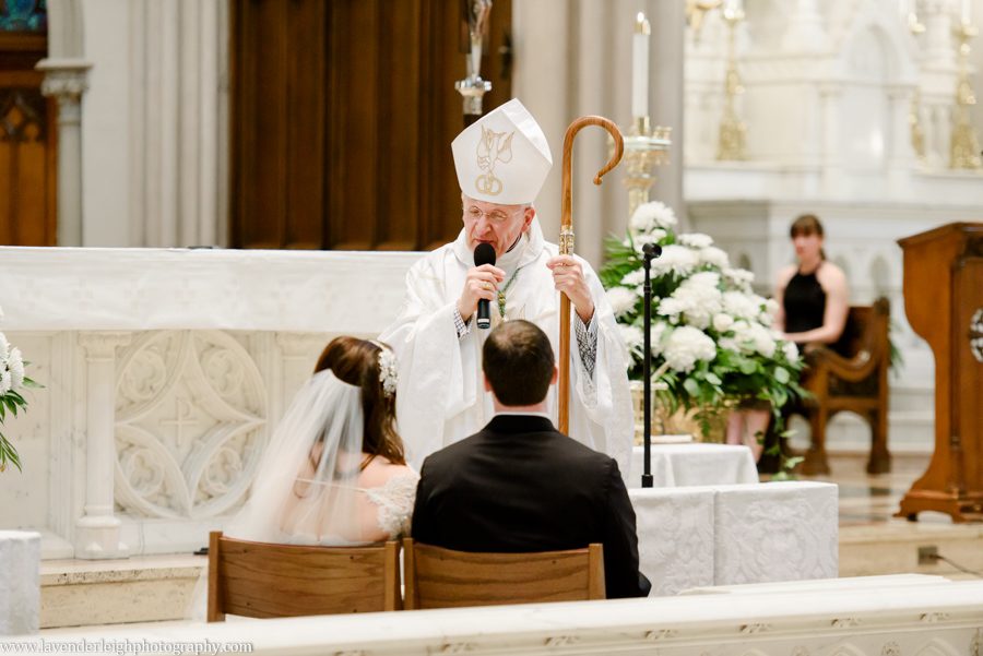 The Arch Bishop of Pittsburgh gives a sermon to a bride and groom during their wedding ceremony at St. Paul Cathedral in Pittsburgh, Pennsylvania