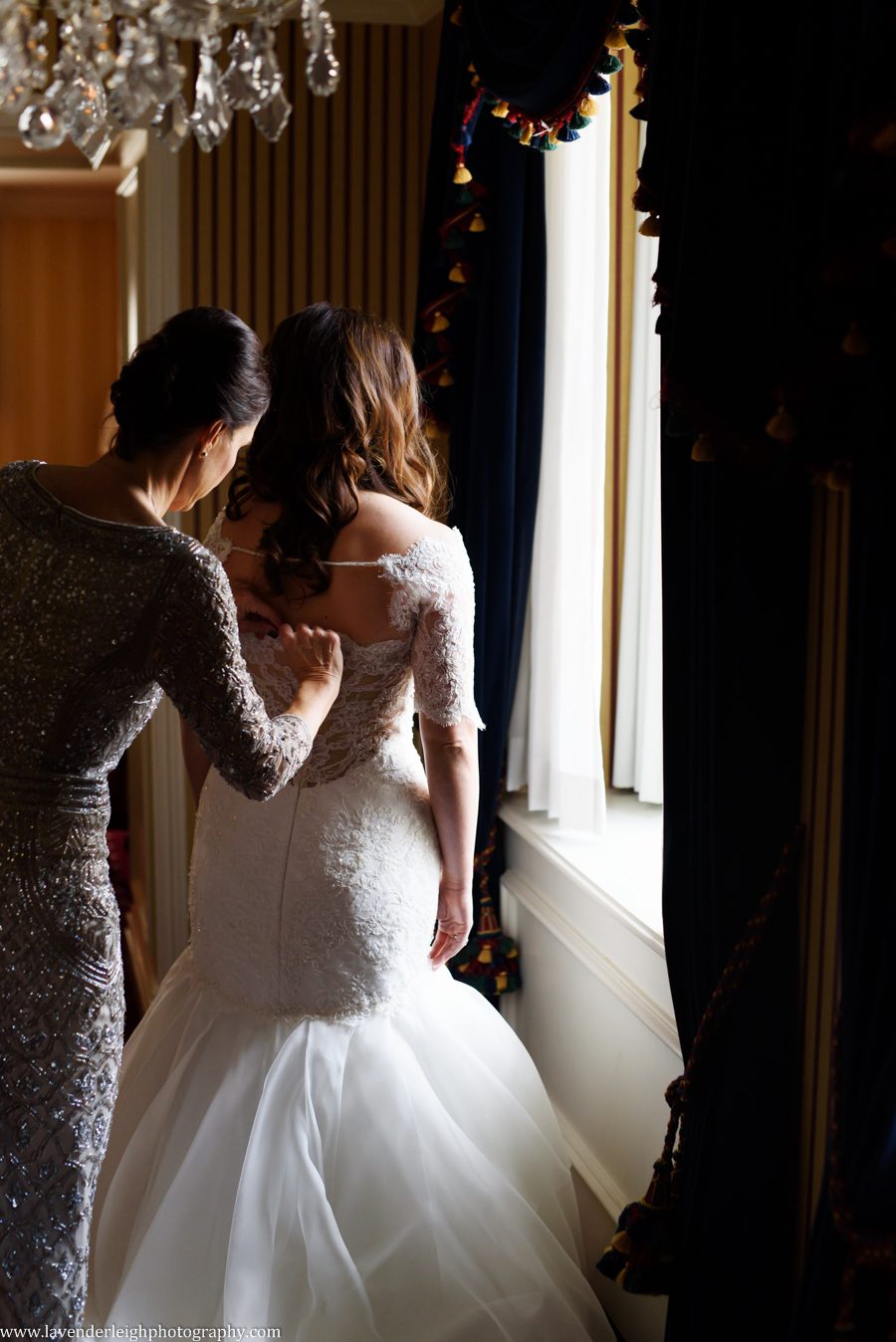 The mother of the bride buttons her dress at the Omni William Penn in Pittsburgh, Pennsylvania