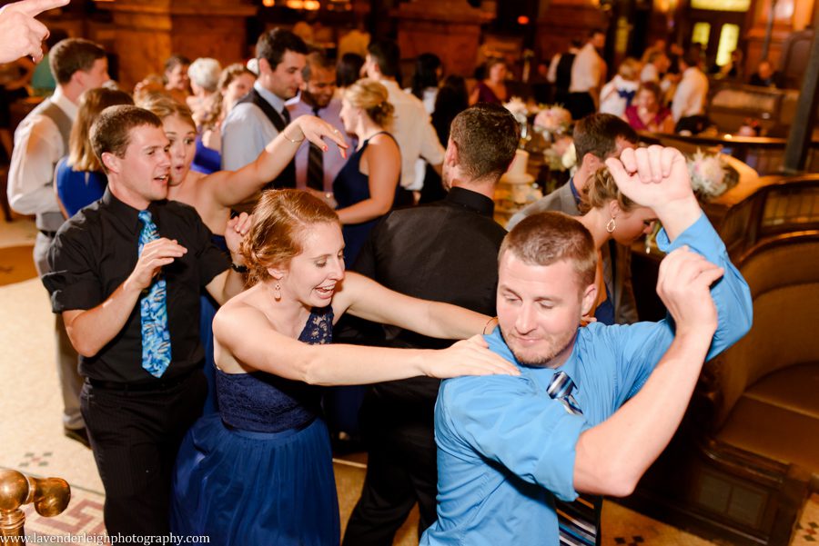 The guests start a dance floor train at a wedding reception at The Grand Concourse in Pittsburgh, Pennsylvania