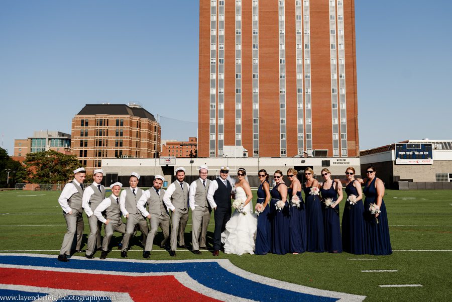 The bride, groom, and their wedding party get creative on the football field at Duquesne University
