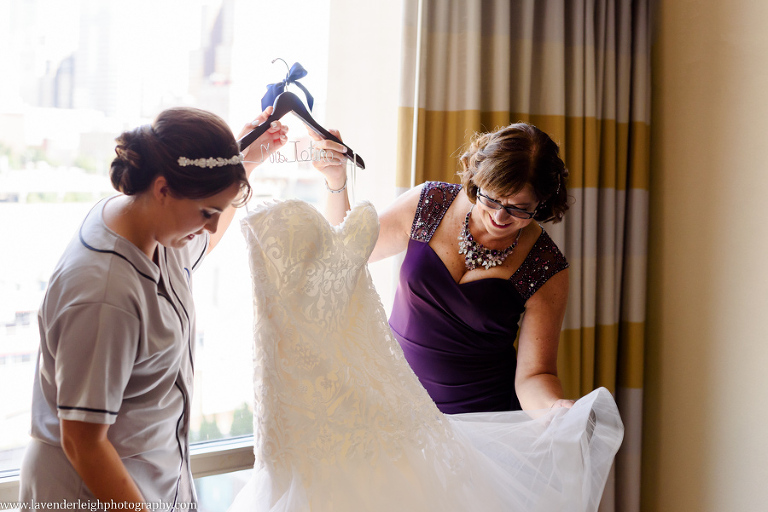 The Mother of the Bride helps her put on her wedding dress