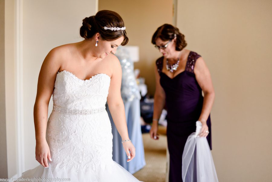 The mother of the bride fluffs the bride's wedding dress train at Sheraton Station Square in Pittsburgh, PA