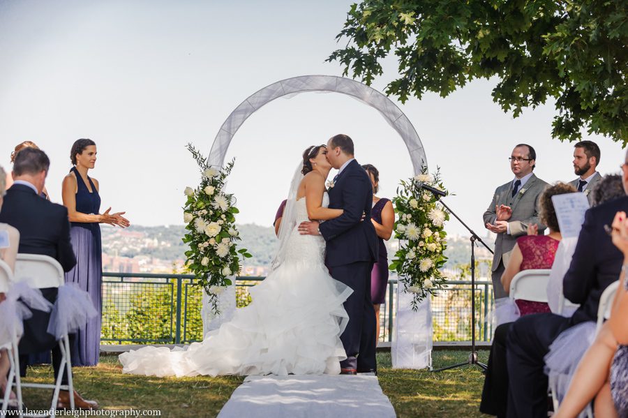 The bride and groom kiss at their wedding ceremony at the West End Overlook in Pittsburgh, Pennsylvania