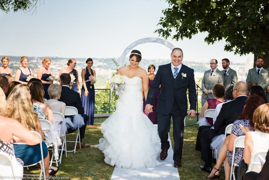The bride and groom exit their wedding ceremony during their recessional at the West End Overlook in Pittsburgh, Pennsylvania