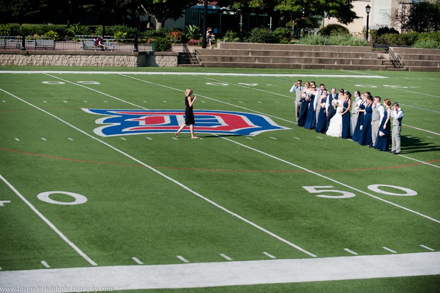 The photographer poses the bridal party at the Duquesne University field.