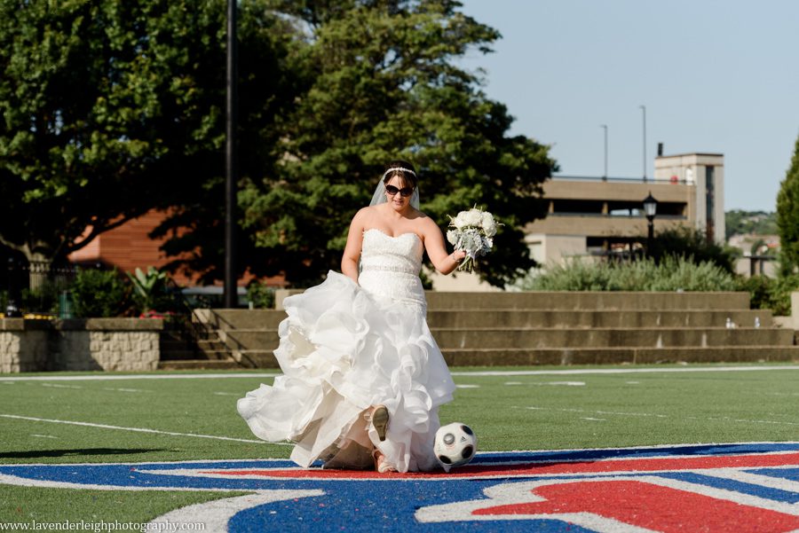 The bride kicks around a soccer ball on the Duquesne University soccer field