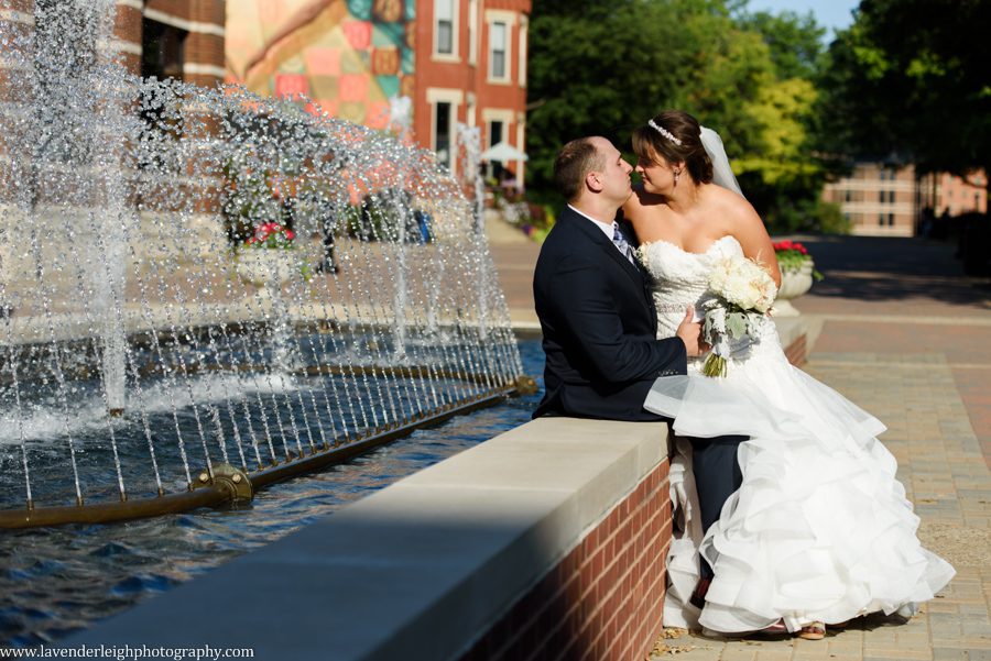 The bride and groom take a moment at the water fountain at Duquesne University