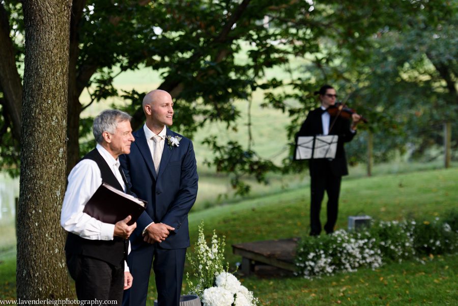 The groom smiles as he sees his bride walking into the wedding ceremony at Greendance, the Winery at Sandhill in Mt. Pleasant, Pennsylvania
