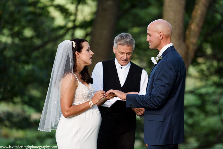 The bride and groom exchange rings during a woodlands wedding ceremony at Greendance, The Winery at Sandhill in Mt. Pleasant, Pennsylvania