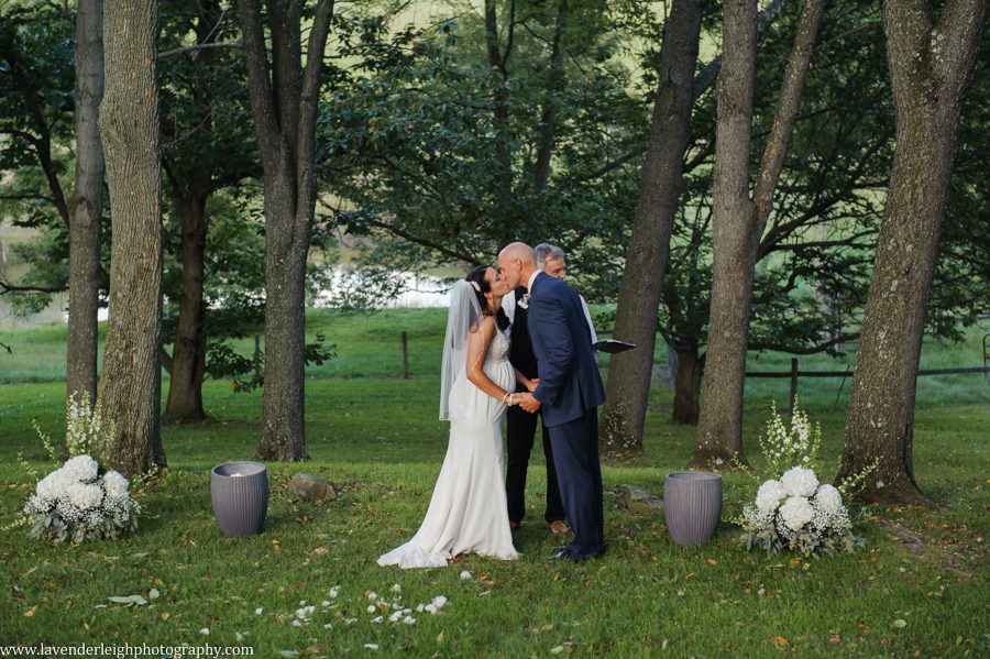 The bride and groom have their first kiss during a wedding ceremony at Greendance, the Winery at Sandhill in Mt. Pleasant, Pennsylvania