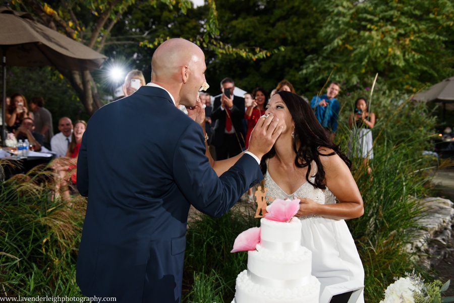The bride and groom feed each other cake at their wedding reception at Greendance, the Winery at Sandhill in Mt. Pleasant, Pennsylvania