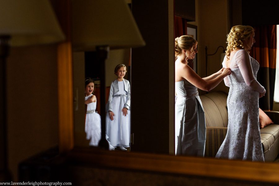 Flower girls are stunned by the beauty of a bride in her wedding dress.