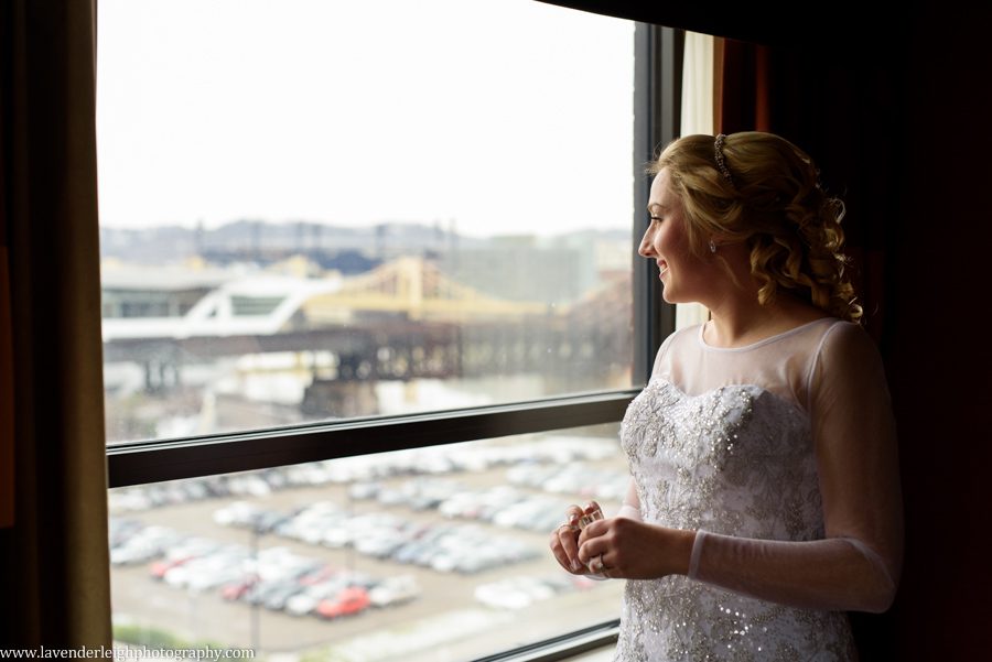 A bride looking out the window and reflecting before her wedding day begins