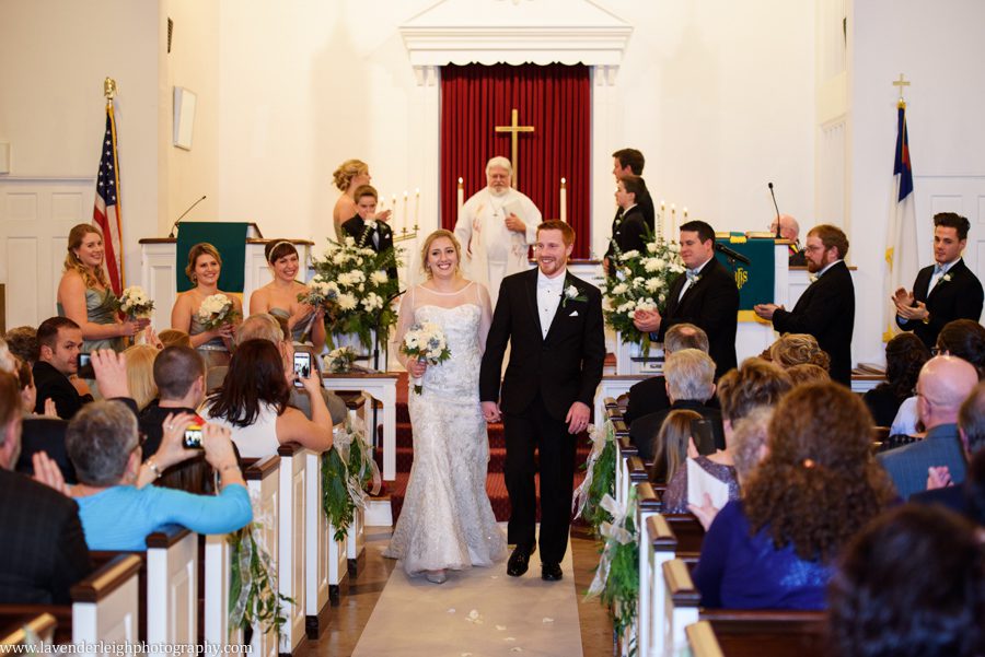 A bride and groom walking out of their ceremony during recessional