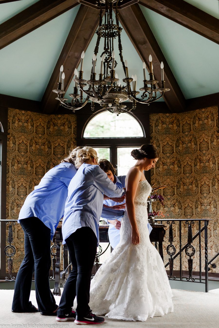 Bridesmaids buttoning bride's dress, the Hyeholde restaurant, castle, Pittsburgh Pennsylvania wedding and engagement photographer
