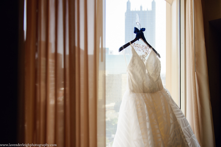 The gorgeous Hayley Paige wedding dress hangs in the city window.