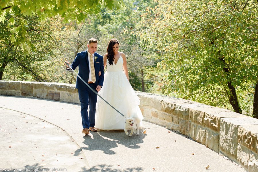 The bride and groom walk their dog at Point State Park in Pittsburgh, Pennsylvania