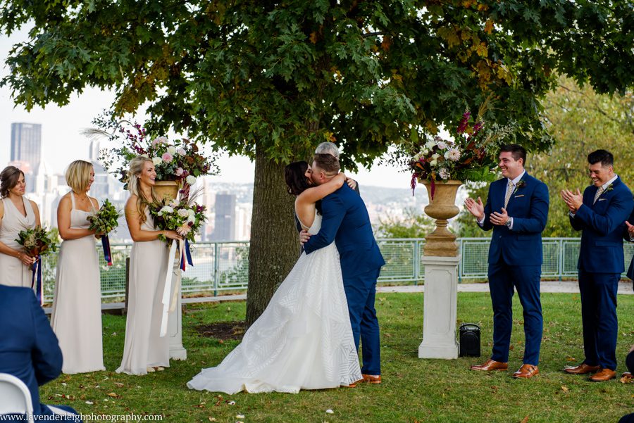 The bride and groom's first kiss during a wedding ceremony at the West End Overlook in Pittsburgh, Pennsylvania