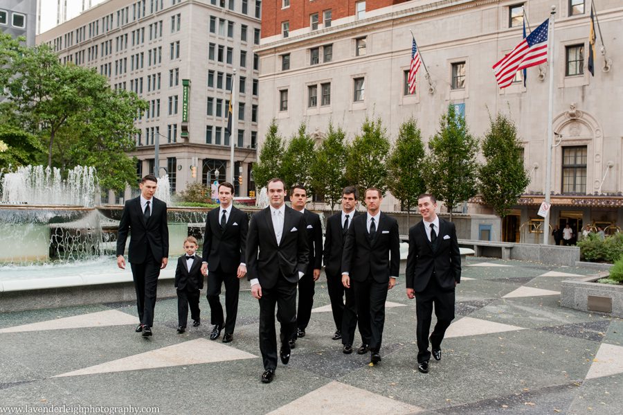The groom walks with his groomsmen through Mellon Square Park