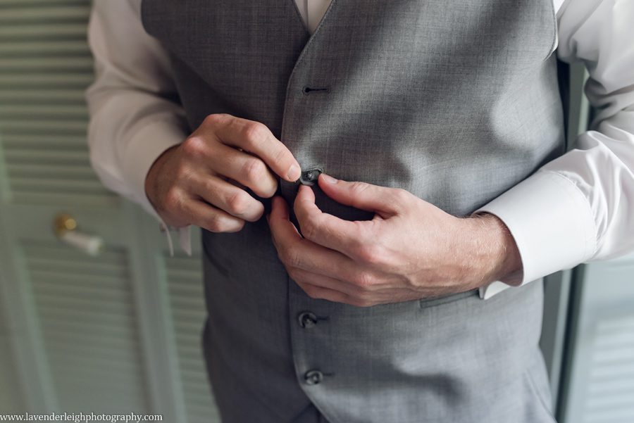 <alt>groom buttoning his vest</alt>