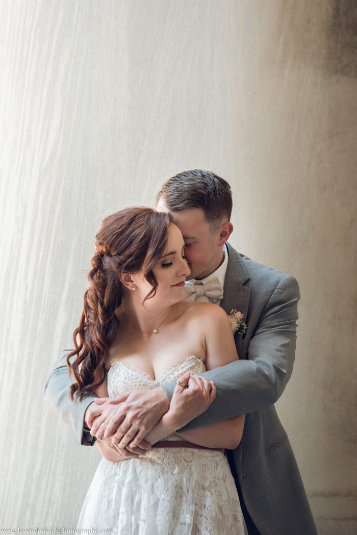 <alt>groom hugs bride at the Pillars in Carnegie Mellon University</alt>