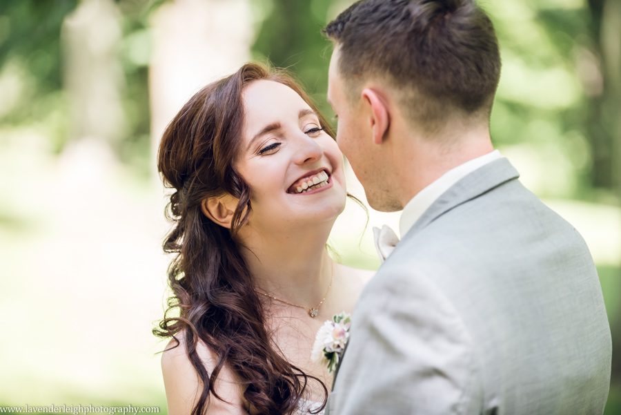 <alt>a bride smiling at her groom as he holds her</alt>