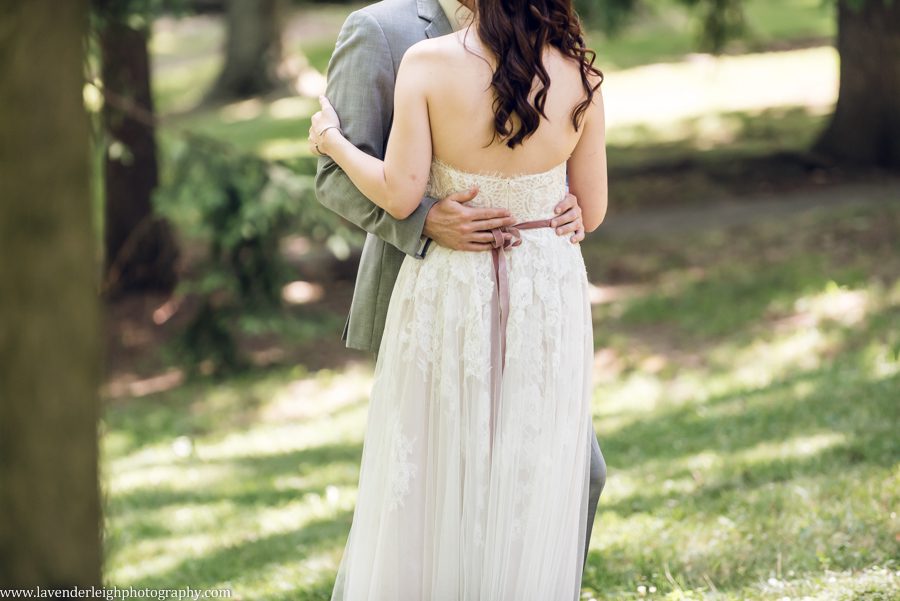 <alt>Bhldn lace dress with pink ribbon on bride</alt>
