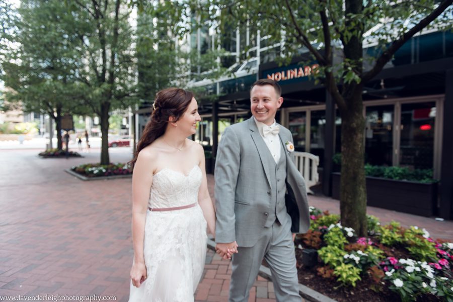 <alt>bride and groom walking through Market Square in Pittsburgh, Pennsylvania</alt>